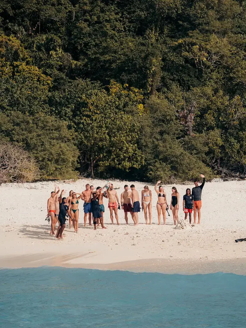 Group arriving at a Palawan beach with expedition gear and dry bags